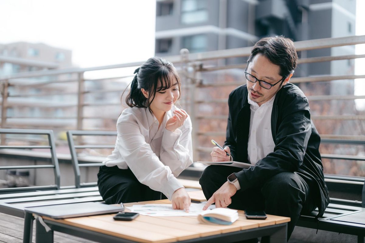 資料を確認しながら取引先と打ち合わせする様子